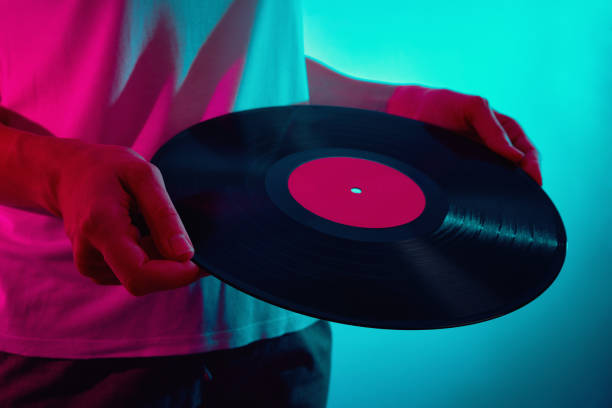 istock Woman hold retro vinyl disc with neon light 1305428671