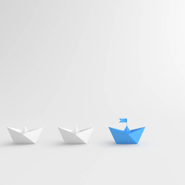Leadership concept, blue leader boat leading white boats, on white background with empty copy space stock photo