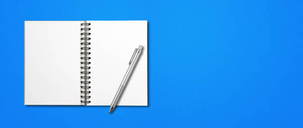 istock Blank open spiral notebook and pen isolated on blue banner 1305432174