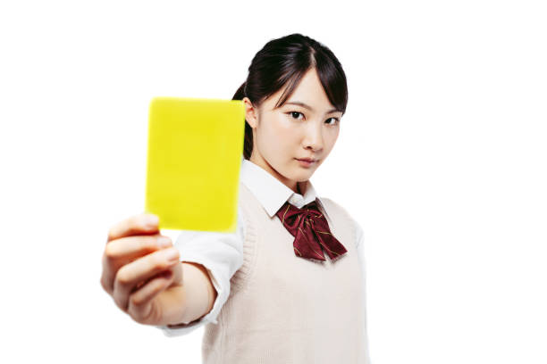 イエローカードを持つアジアの女子高生。 - yellow card ストックフォトと画像