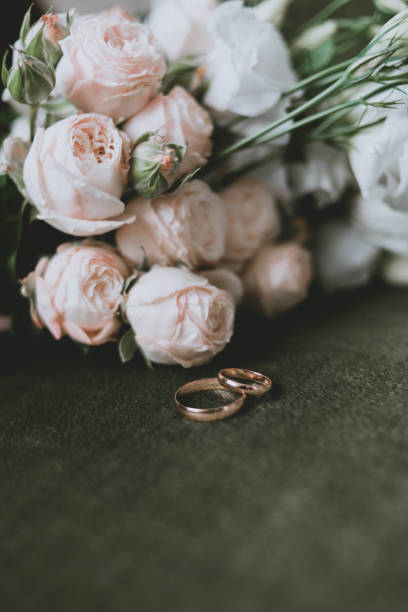 istock wedding bouquet and rings on a green background. Wedding 1305433499