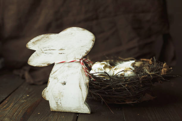 istock easter background with bunny figure and golden easter eggs in a nest on a dark wood background in vintage style 1305433877