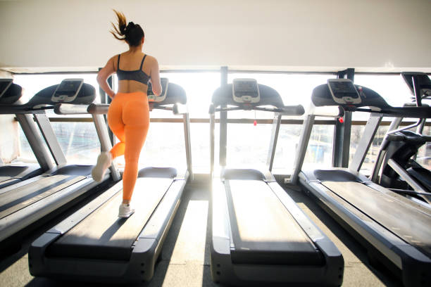 istock Young woman running on a treadmill 1305434412