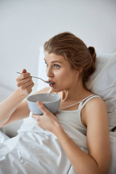 istock Thoughtful young woman having breakfast in bed 1305434658