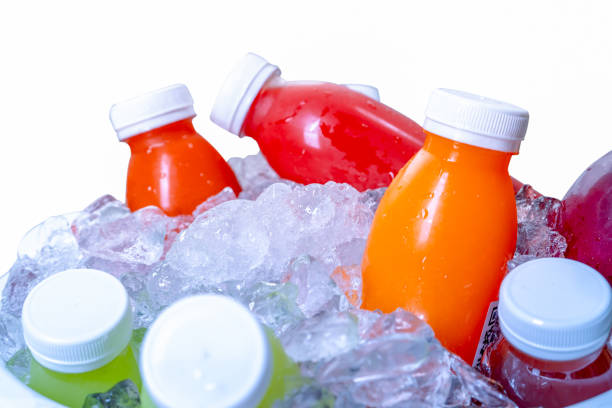 istock Organic cold-pressed raw vegetable and fruit juice bottle in crushed ice bucket on white background. Healthy drink. Trendy juice beverage. Detox juice from fresh fruits and vegetables. Orange juice. 1305435709