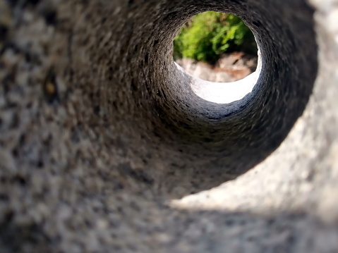 interesting abstract view threw a hole in a stone to green bushes