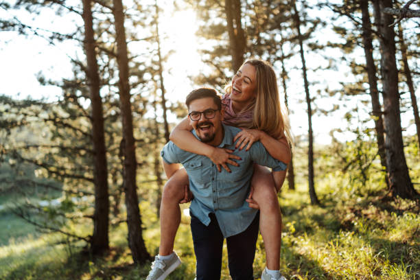 istock Piggyback ride through sunny woods 1305440709