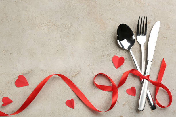 istock Cutlery set and red ribbon on light background, flat lay with space for text. Valentine's Day dinner 1305441576