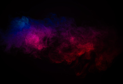 Motion blur of grainy steam in pink and blue light.