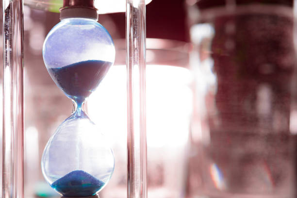 istock Blue hourglass on gray background close up 1305443521