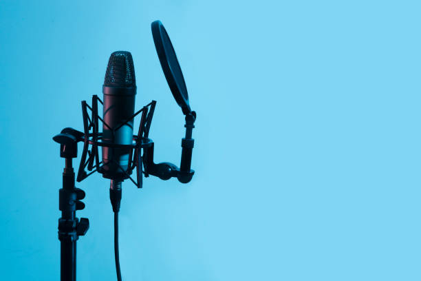 istock Professional microphone with waveform a on blue background banner. Podcast or recording studio background 1305444019