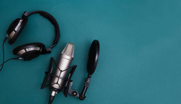 istock Professional microphone with waveform and headphones on background banner. Podcast or recording studio background 1305444020