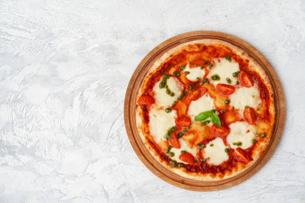 istock Top view of pizza Margherita on gray surface 1305444418