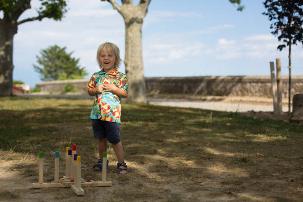 istock Child, boy, playing game with hoops and rings, throwing and trying to strike a point 1305445513