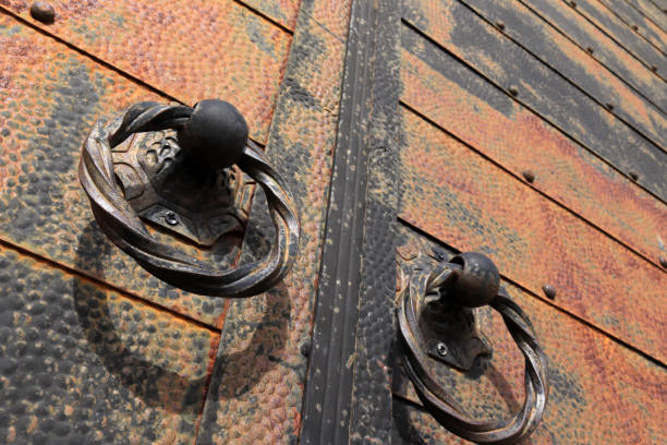 istock Old riveted iron door.Metal handles. 1305451163
