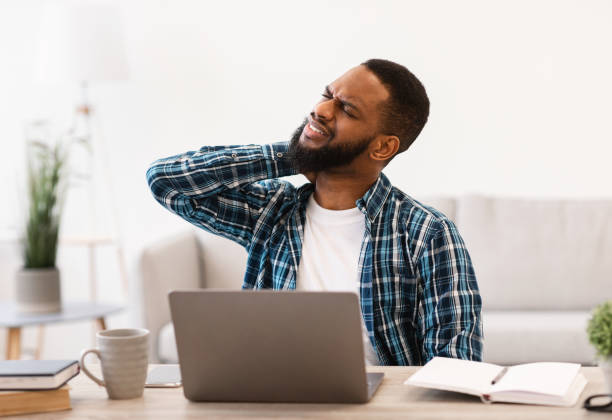istock Black Man Suffering From Neck Pain After Work In Office 1305453804