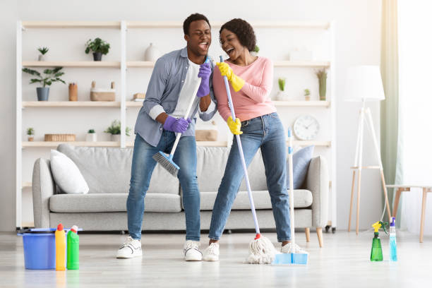 istock Young couple cleaning home, having fun with mop and broom 1305455262