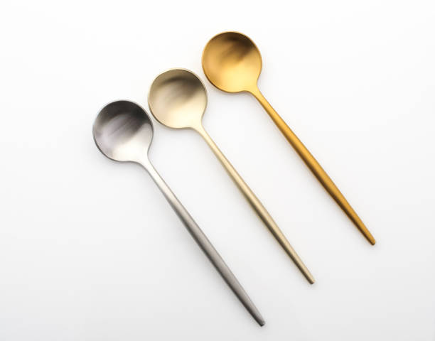 istock Metal teaspoons on a white background. Gold and silver spoons 1305456701