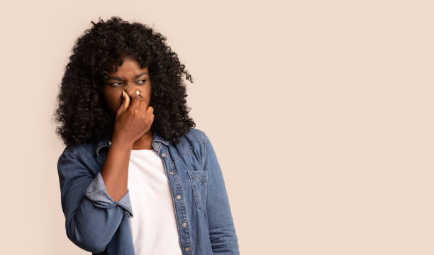 Black woman closing nose with fingers, feeling unpleasant scent Portrait of black woman closing nose with fingers, feeling unpleasant scent, african american lady suffering from stench, smelly sweaty person bring discomfort, looking at copy space, panorama body odor stock pictures, royalty-free photos & images