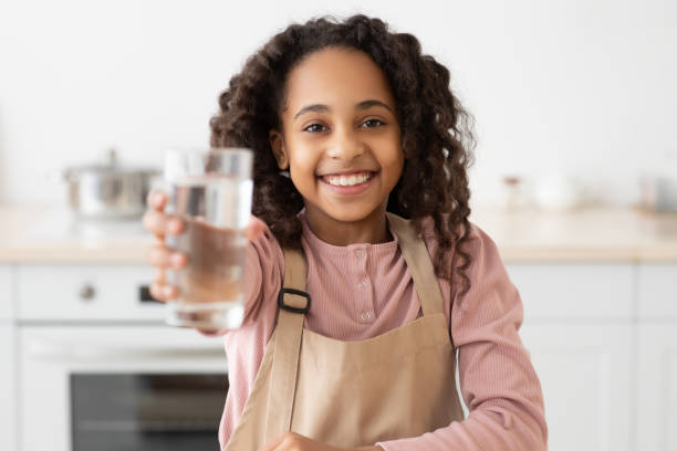 african american kręcone dziewczyna gospodarstwa szklankę świeżej wody - glasses child little girls african ethnicity zdjęcia i obrazy z banku zdjęć