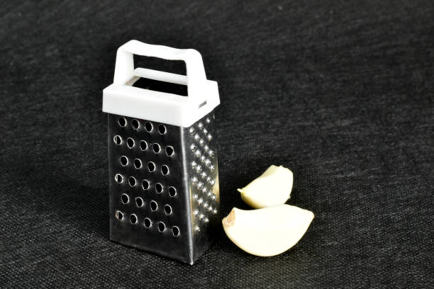 istock Small metal grater and garlic cloves. 1305460121