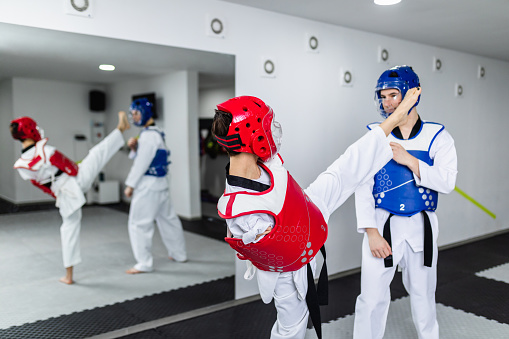 Young disabled woman born without arms training taekwondo with her coach.
