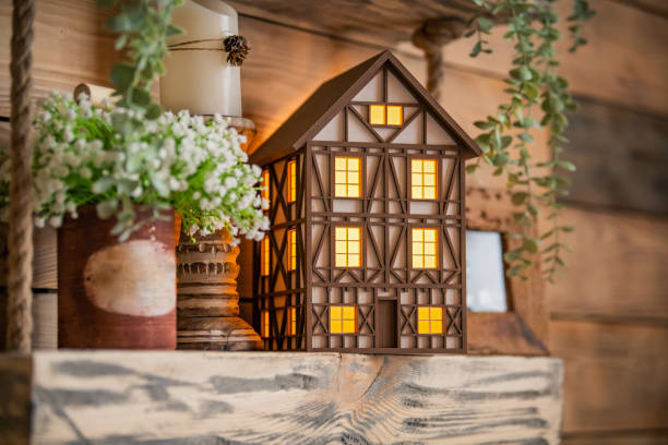 istock toy decorative lamp house stands on wooden table among spring flowers and interior elements. 1305460702