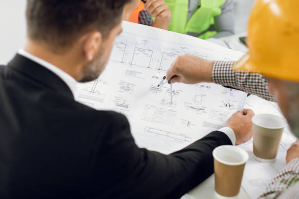 istock Group of colleagues creating plan of building at office 1305462619