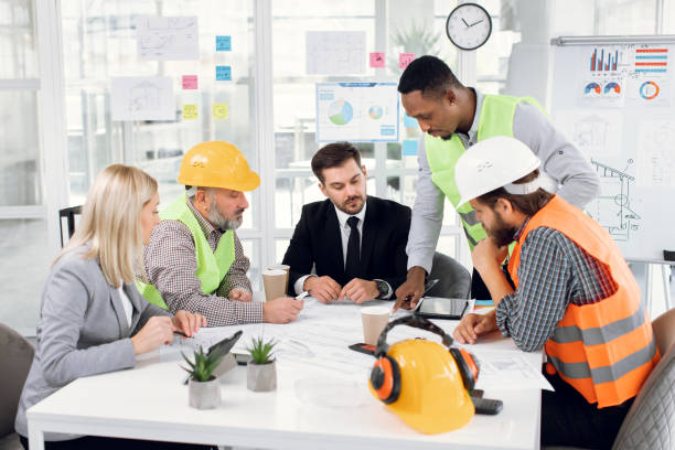istock Multicultural partners working with drawings inspection in modern light office 1305462837