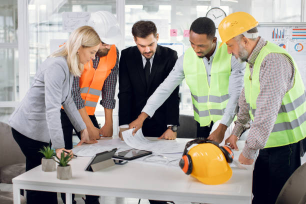 istock Diverse group of specialists working with blueprints 1305462903