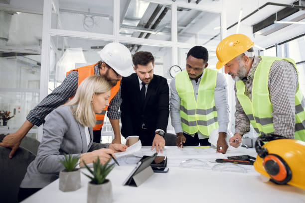 istock Diverse group of specialists working with blueprints 1305462915