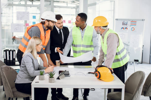 istock Diverse group of specialists working with blueprints 1305462961