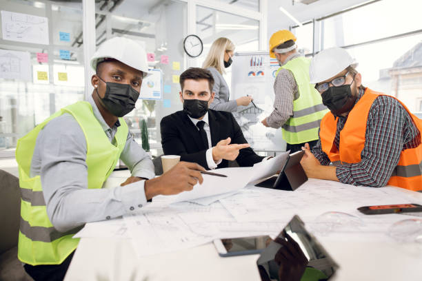 istock Partners in medical masks discussing new construction plan 1305463558