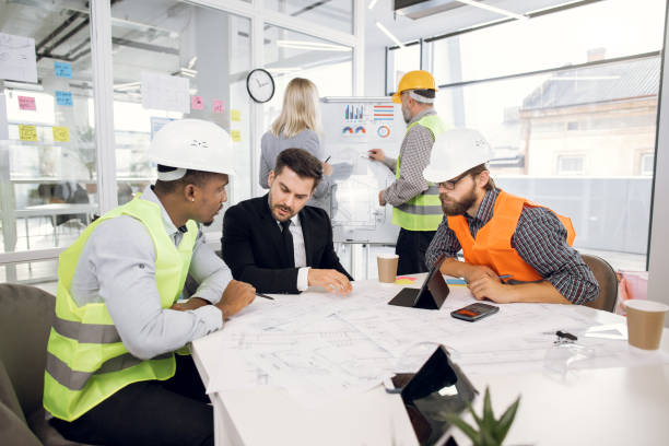 istock Multiethnic group of engineers and builders, working together over joint building project 1305463564