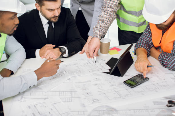 istock Focused business people working with blueprints indoors 1305463586
