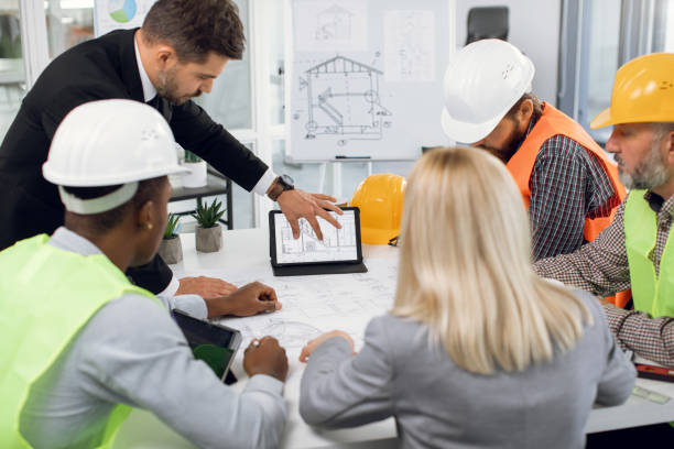 istock Multiethnic professional team of engineers and managers, brainstorming together over construction project 1305463610