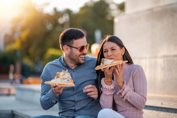 istock Man and woman eating pizza 1305464232
