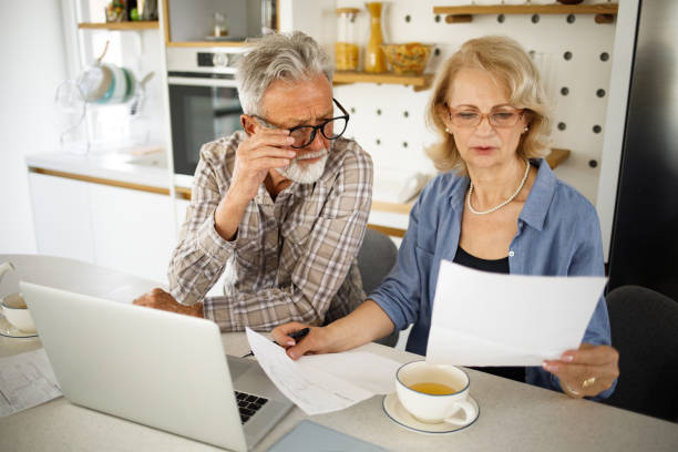 istock Senior couple checking their bills using laptop in the kitchen 1305464339