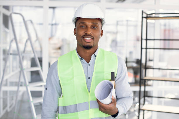 istock Confident afro-american man in hardhat standing indoors 1305465051