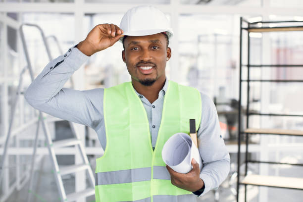 istock Positive african engineer in helmet controlling construction 1305465072