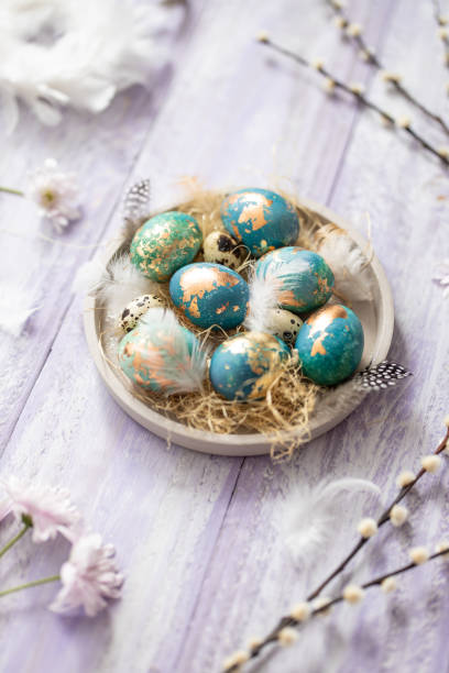 istock Blue Easter eggs on purple wooden table background 1305466519