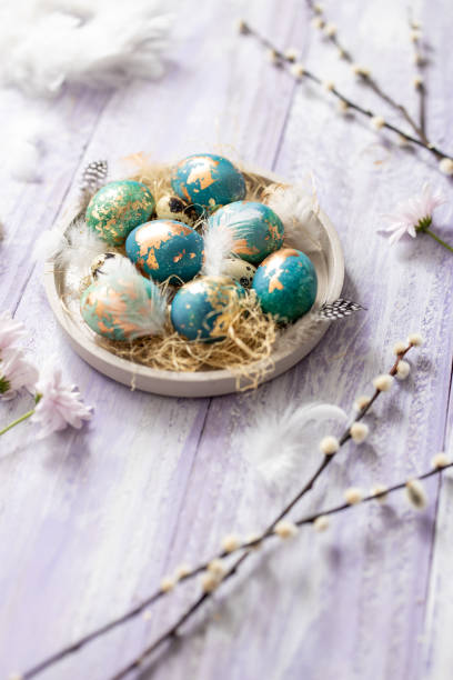 istock Blue Easter eggs on purple wooden table background 1305467077
