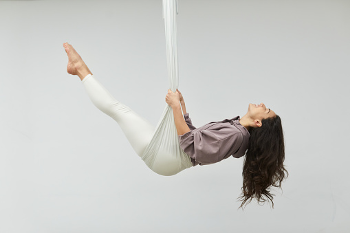 Yoga Pilates and barre studio\nBarcelona. Italian yoga instructor.\nOne woman practicing aerial yoga.
