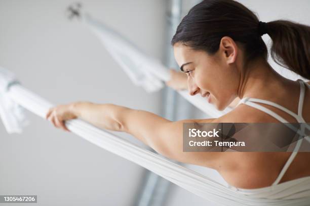 One Woman Practicing Flying Yoga Stock Photo - Download Image Now - Aerial Yoga, Yoga, Flying