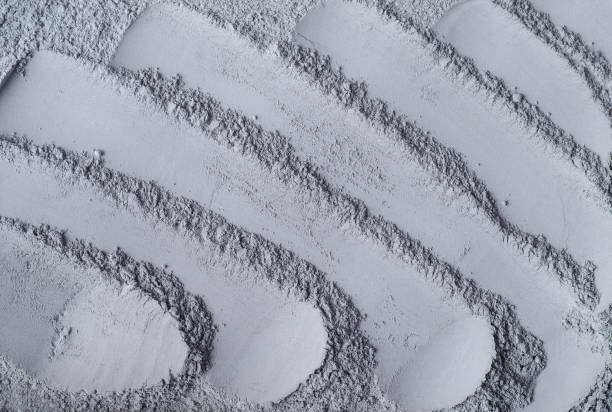 istock Gray bentonite clay powder (alginate, facial mask, eye shadow, body wrap) texture close up, selective focus. Abstract background. 1305467786