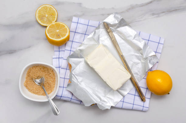 istock Top view of fresh utter, brown sugar, lemons, napkin and knife on the white kitchen table 1305471180