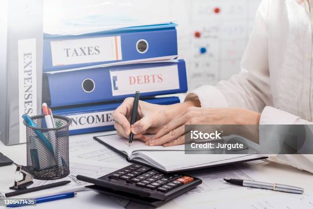 Person Accounting Incomes And Expenses Of A Company Calculating Taxes Concept Of Work In Accountant Department Stock Photo - Download Image Now
