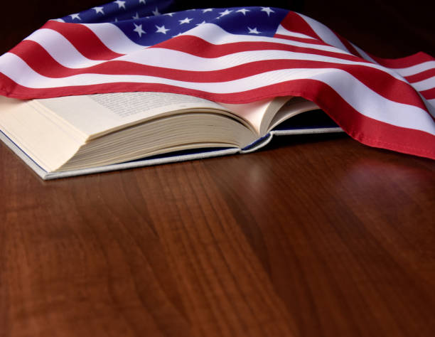 istock Open book with the American flag on the table frame stock images 1305472803
