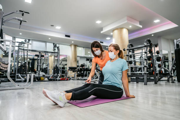 istock Senior woman stretching with trainers help 1305473921