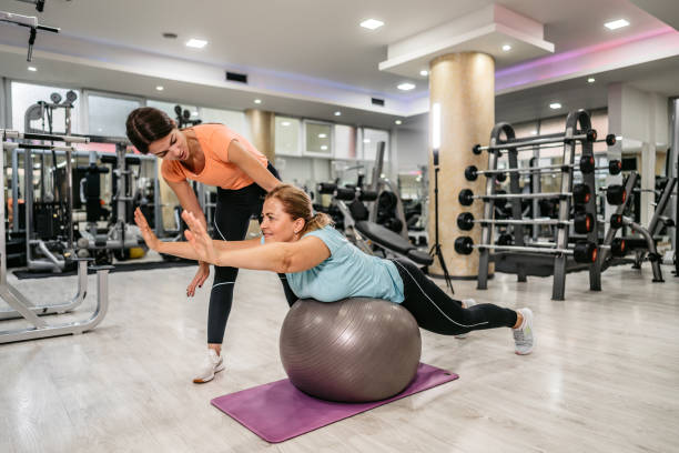 istock Senior woman stretching with trainers help 1305474033